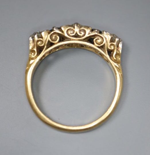 An early 20th century 18ct gold three stone diamond and two stone sapphire set half hoop ring, size K, gross 3.6 grams.